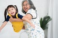 Happy Asian senior grandmother holding and playing with granddaughter in the living room, happy grandma wearing glasses and Royalty Free Stock Photo