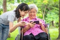 Happy asian senior grandmother and little child girl using cellphone together,playing video game on smart phone,smiling elderly