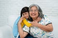 Happy Asian senior grandmother sit on a couch and  granddaughter Royalty Free Stock Photo