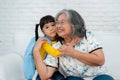 Happy Asian senior grandmother sit on a couch and  granddaughter Royalty Free Stock Photo