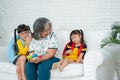 Happy Asian senior grandmother sit on a couch and  granddaughter Royalty Free Stock Photo