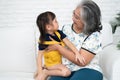 Happy Asian senior grandmother sit on a couch and  granddaughter Royalty Free Stock Photo