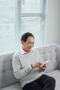 Happy asian senior man using the mobile phone at home Royalty Free Stock Photo