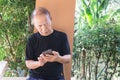 Happy asian senior man using the mobile phone at home Royalty Free Stock Photo