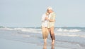 Happy Asian senior man and woman couple smile dancing resting relax on the beach Royalty Free Stock Photo