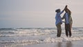 Happy Asian senior man and woman couple smile dancing resting relax on the beach Royalty Free Stock Photo