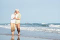 Happy Asian senior man and woman couple smile dancing resting relax on the beach Royalty Free Stock Photo