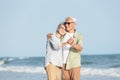 Happy Asian senior man and woman couple smile dancing resting relax on the beach Royalty Free Stock Photo