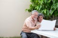 Happy Asian senior mature couple reading newspaper at front garden home Royalty Free Stock Photo