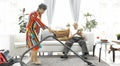 Happy asian senior man playing tablet computer and Senior woman vacuuming floor at home Royalty Free Stock Photo