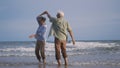 Happy Asian senior man and woman couple smile dancing resting relax on the beach Royalty Free Stock Photo