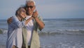 Happy Asian senior man and woman couple smile dancing resting relax on the beach Royalty Free Stock Photo