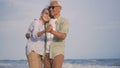 Happy Asian senior man and woman couple smile dancing resting relax on the beach Royalty Free Stock Photo