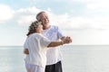 Happy senior retired couple dancing with relax smiling  on sea beach, elder man and woman enjoying with retired vacation. Royalty Free Stock Photo