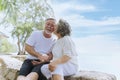 Happy asian senior retired couple, relax smiling elder man and woman enjoying with retired vacation at sea beach outdoor. Health Royalty Free Stock Photo