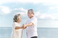 Happy asian senior retired couple, relax smiling elder man and woman enjoying with retired vacation at sea beach outdoor. Health Royalty Free Stock Photo