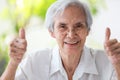 Happy asian senior woman give thumb raised up,feel fit and healthy,Smiling old elderly showing two thumbs up gesture at her good