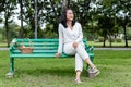 Happy asian senior woman sitting on green chair with basket apple and flower picnic in public park Royalty Free Stock Photo