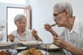 Happy asian senior women eating Thai food,local cuisine,sitting at dining table in the house,old people are enjoying lunch,eat