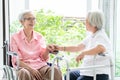 Happy asian senior woman sitting on wheelchair,sister or friend with walker having fun,friendly,female elderly people is smiling Royalty Free Stock Photo