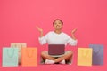 Happy Asian Shopaholic Lady Sitting Among Bright Shopping Bags And Using Laptop Royalty Free Stock Photo