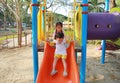 Happy asian sister and her little brother enjoy playing slider in playground in the park. Child girl play with her brother outdoor Royalty Free Stock Photo