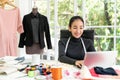 Happy asian smart looking fashion designer smiling,sitting in modern office studio