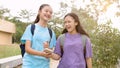 Happy Asian student girls walking and using smart phone in school Royalty Free Stock Photo