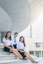 Happy asian students in uniform siting at university Royalty Free Stock Photo