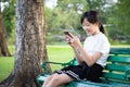 Happy asian teenage girl holding cellphone having fun,female people playing game,chat,talk to friends on the smartphone while Royalty Free Stock Photo
