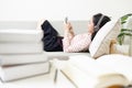 Happy asian teenage girl wearing headphones lying on the couch,resting and listening to music online on mobile phone,enjoy and Royalty Free Stock Photo