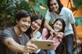 Happy asian teenagers taking pictures by themselves having fun Royalty Free Stock Photo