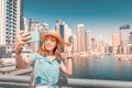 Asian tourist girl takes selfie photos in popular Marina district in Dubai for her social media and blog