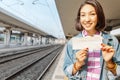 Tourist woman showing blank ticket at the platform of the metro or train station