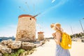 Asian traveler girl posing near famous Rhodes attraction - old windmills. Vacation in Greece concept Royalty Free Stock Photo