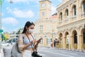 Happy Asian traveler woman looking a map on mobile phone while walking at old town Phuket, Thailand. Travel alone concept Royalty Free Stock Photo