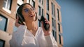 Happy asian woman businesswoman business lady female student listening music sing in headphones using mobile phone Royalty Free Stock Photo