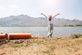 Happy asian woman in casual style clothing raised up arms and standing in the river with mountain view Royalty Free Stock Photo