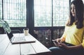 Happy Asian woman chatting on her mobile phone while relaxing in cafe during free time, Royalty Free Stock Photo