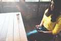 Happy Asian woman chatting on her mobile phone while relaxing in cafe during free time, Royalty Free Stock Photo