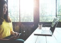 Happy Asian woman chatting on her mobile phone while relaxing in cafe during free time, Royalty Free Stock Photo