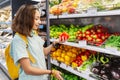 Asian woman choosing for purchase vegetables at the supermarket. Organic vegetarian food concept Royalty Free Stock Photo