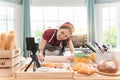 Happy asian woman is cooking cookies and having fun in the kitchen. She making video for her culinary vlog Royalty Free Stock Photo