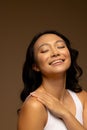 Happy asian woman with dark hair, with hand on shoulder and eyes closed, copy space Royalty Free Stock Photo