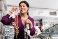 Happy asian woman demonstrating ornaments in jewelry store