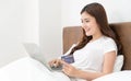 Happy asian woman doing online shopping at home, Women shopping online with credit card and laptop on the bed at home Royalty Free Stock Photo