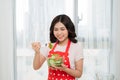 Happy asian woman eating salad from glass bowl. Halthy food.