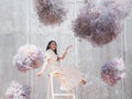 Happy asian woman with floating pastel flowers