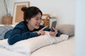 Happy asian woman hand using smartphone typing, chatting conversation in chat box on her bedroom, Social media maketing Royalty Free Stock Photo