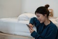 Happy asian woman hand using smartphone typing, chatting conversation in chat box on her bedroom, Social media maketing Royalty Free Stock Photo